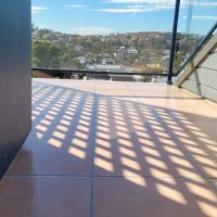 An image of a leaking balcony after it has been treated with a re-grout, silicone where the grout cracks were excessive and a remedial membrane to top it off